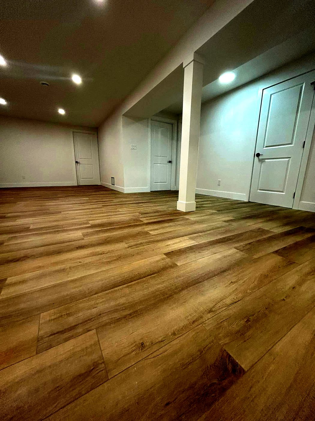 Newly installed wide-plank hardwood flooring in a bright renovated room